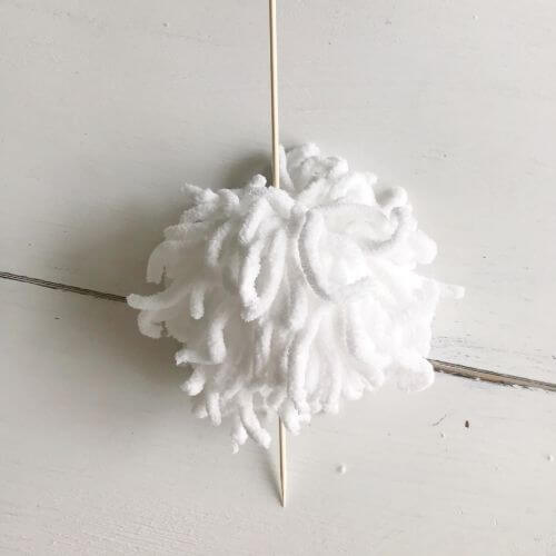 Pom pom with bamboo skewer through it