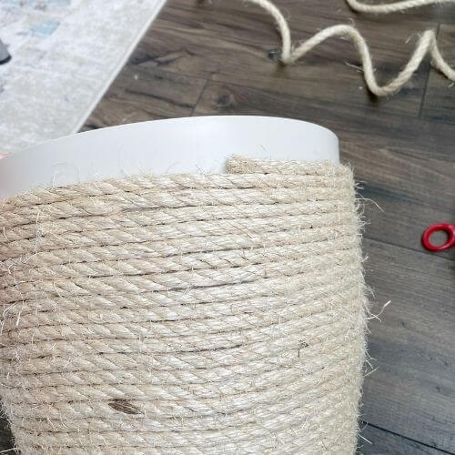 Use glue to continue to secure rope to your plastic pot