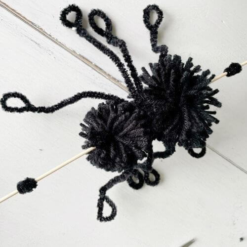 Place pipe cleaners on each end of skewer to hold pom-pom on