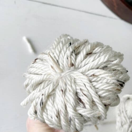 Place skewer through middle of yarn flower