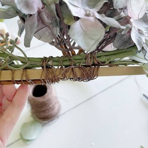 Secure a eucalyptus stem to either side of the hydrangea using wire