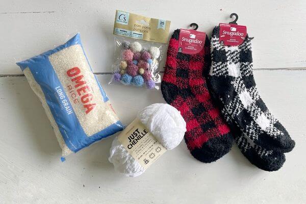 Supplies for gnomes including socks, rice, yarn and pom-poms