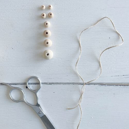 Eight wood beads, jute twine and scissors