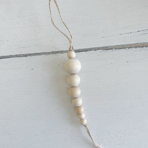 Tie a double knot at the top and bottom of the string of wood beads