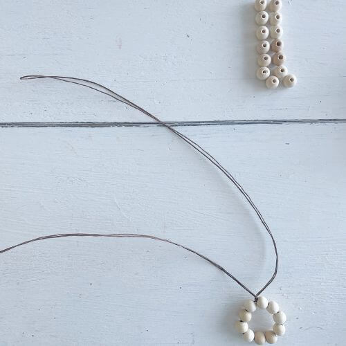 Place ten beads onto the wire and then form into a circle. Twist the wire twice to secure the circle. 