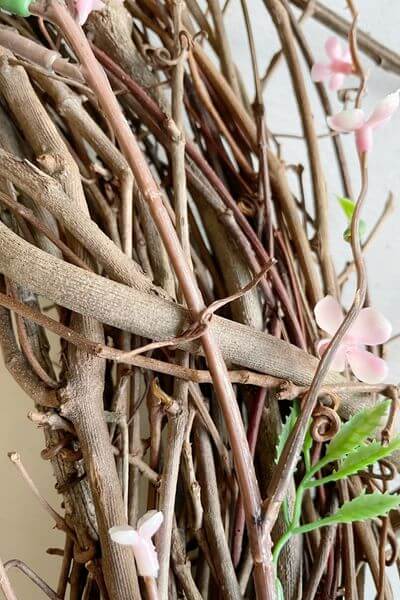 Twist around pink floral branches to secure them to grapevine wreath.