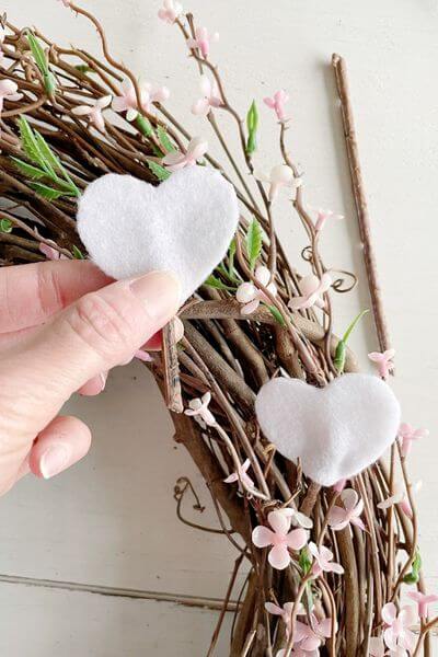 After securing stem between two felt hearts with hot glue, poke down into the wreath. 