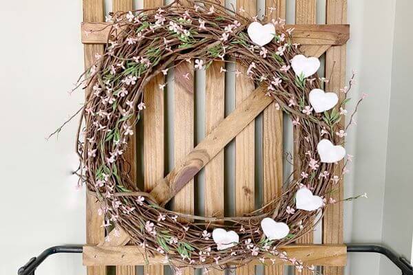 FInished Valentine wreath hung on decorative fence.