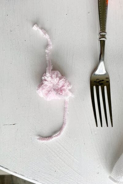Tie the pom-pom in the middle and remove from the fork. 