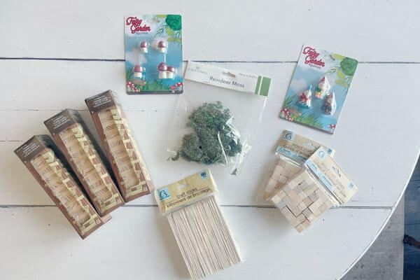 Supplies including Jenga game, wood blocks, craft sticks, reindeer moss and gnome figurines.