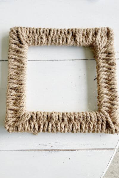 Square wire wreath frame completely wrapped with jute rope.