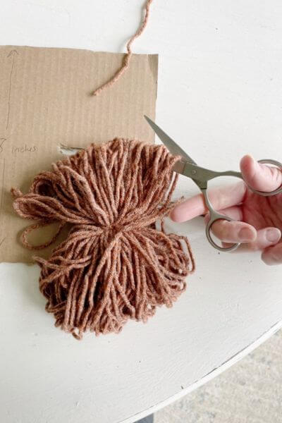 Cut one end of pom-pom with a pair of scissors.