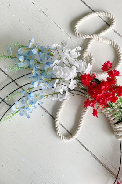 Blue Larkspur floral stem tucked into the rope wreath.