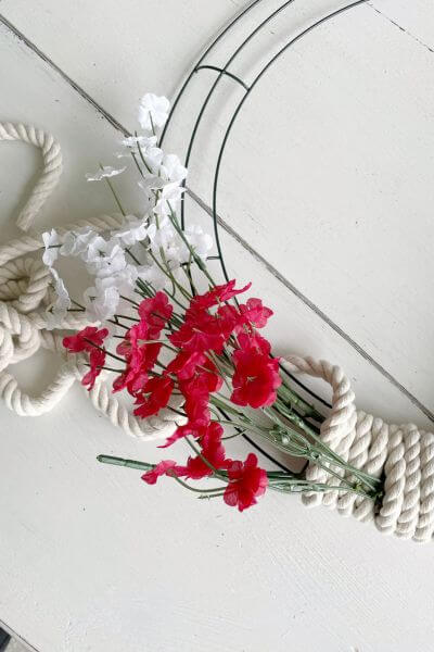 Push the stem of the white Baby's Breath into the tunnel created by wrapping your rope. 