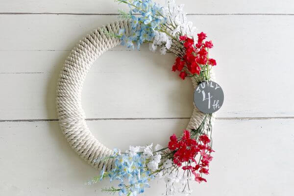 Patriotic floral rope wreath DIY on white table.