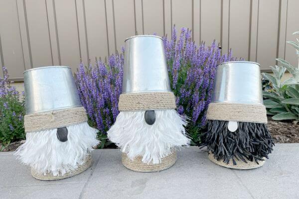 Three garden gnomes made out of Dollar Tree galvanized vases.