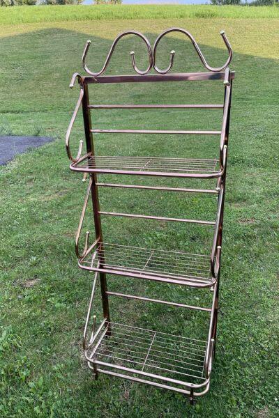 Free standing metal shelf with three tiers.