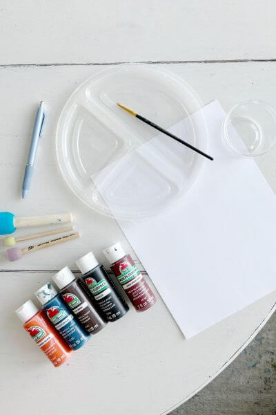 Supplies including cardstock, craft sponges, paint, paintbrush, paint tray and pen.