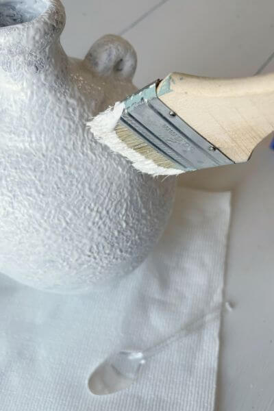 Use the end of the brush to blot the paint and baking soda mixture onto the vase. 