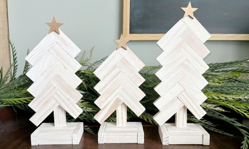 Three whitewashed tumbling tower block Christmas trees with gold stars on top.