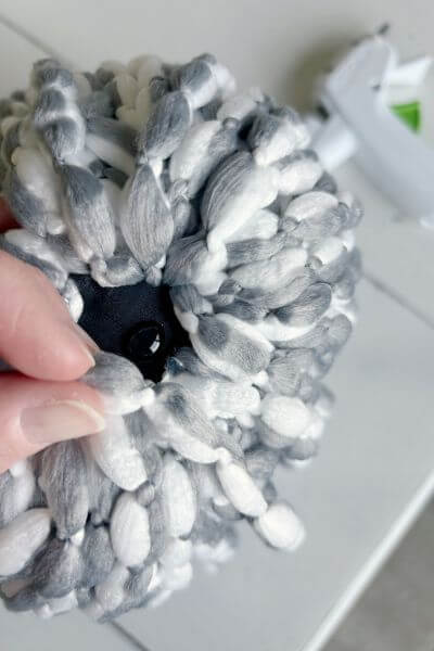 Apply hot glue and as you make loops secure the strands to the top plastic area covering it.