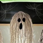 Three light up mop head ghosts made with Dollar Tree supplies.