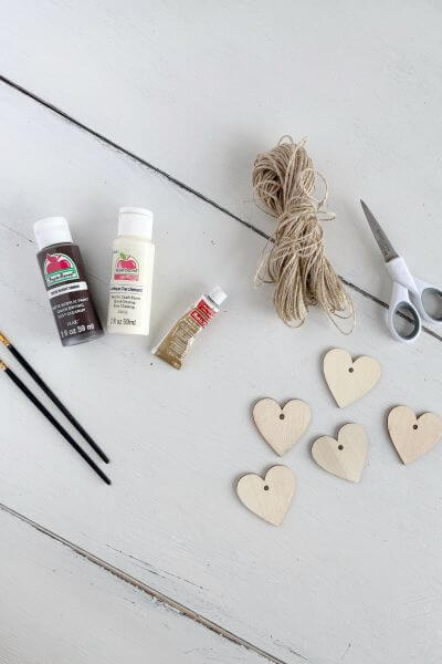 Supplies including wood hearts, twine, paint, rub n' buff, scissors and craft paintbrushes.