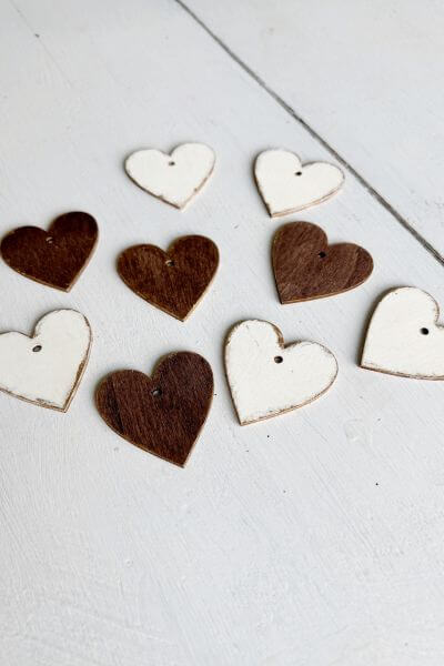 Wood hearts painted brown and white with gold edges. 