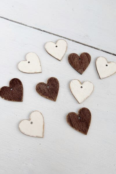 Wood hearts painted brown and white with gold edges.