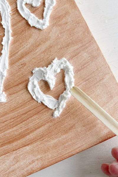 Use a clean popsicle stick to scrape and press it to reduce spackle smudges. 