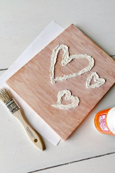 Apply mod podge over the spackle and canvas using a chippy brush. 