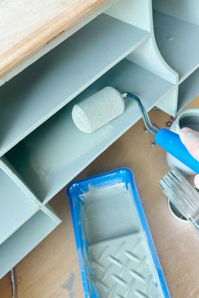 Using a roller to paint the cubbies. 