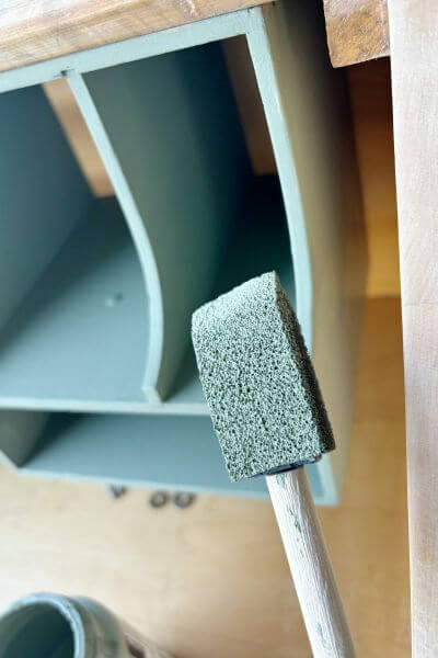 Craft sponge to get in small space between the edge of cubby and inside wall of desk. 