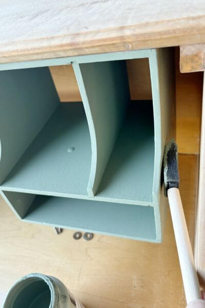 Craft sponge to get in small space between the edge of cubby and inside wall of desk. 