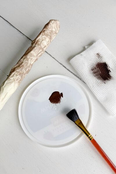 Dry brush brown paint onto masking tape. 