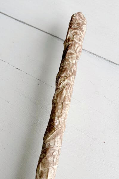 Finished broom handle with brown paint dry brushed onto masking tape. 