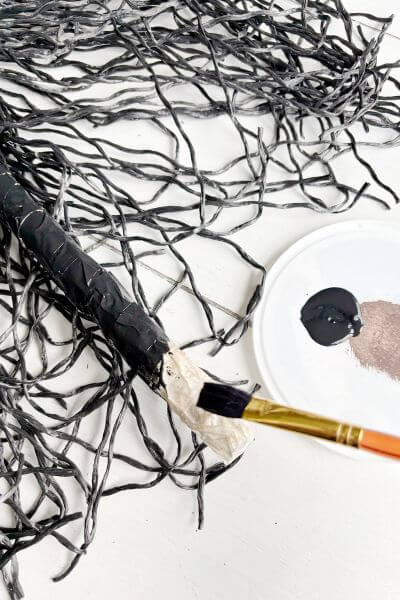 Painting the bottom of the broom handle black to hide it under the poly rope. 