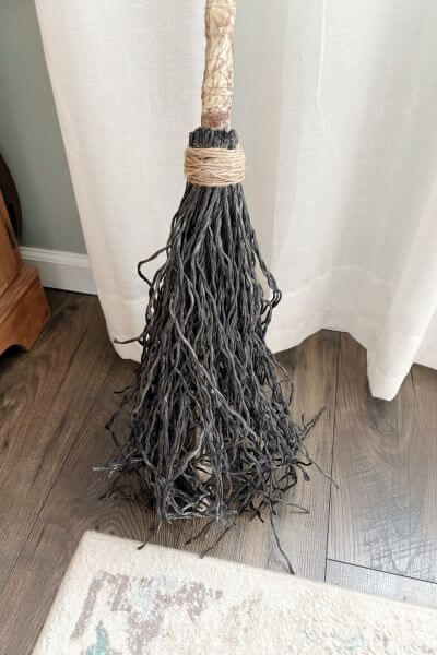 Broom with part of the handle showing through the rope. 