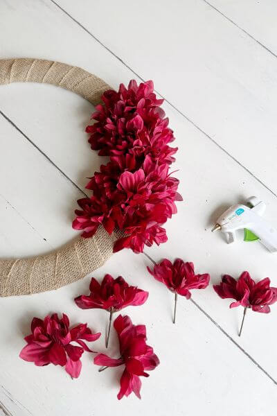 Third bunch of dahlias sitting next to wreath and glue gun. 