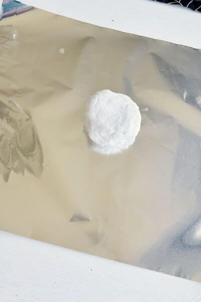 Chunk of clay sitting on tin foil. 