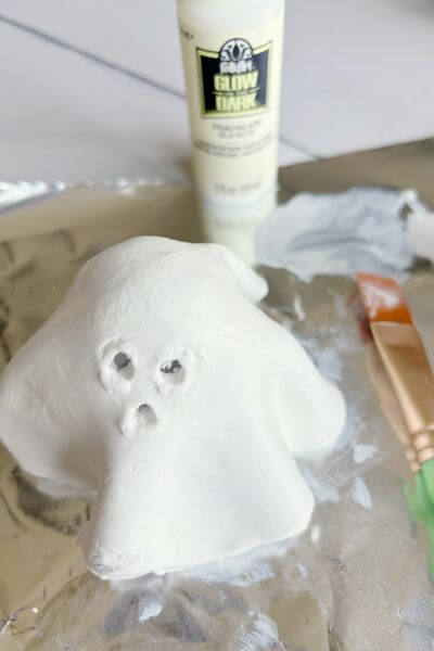 Apply three layers of glow in the dark paint to the ghost. 
