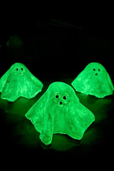 Three glow in the dark clay ghosts at night. 