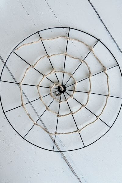 First roll of jute wire wrapped around inside of bicycle wheel wreath form to make a web. 