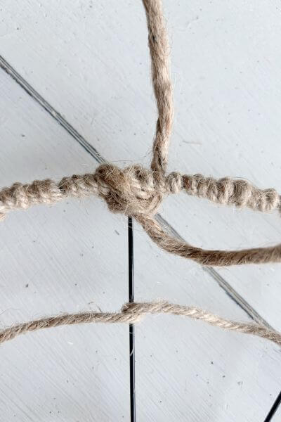 Cross one end of the jute wire in front and back through the wire form.
