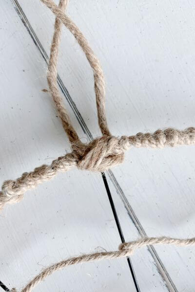 Jute wire hanger looking like a knot in the front of the wreath form. 