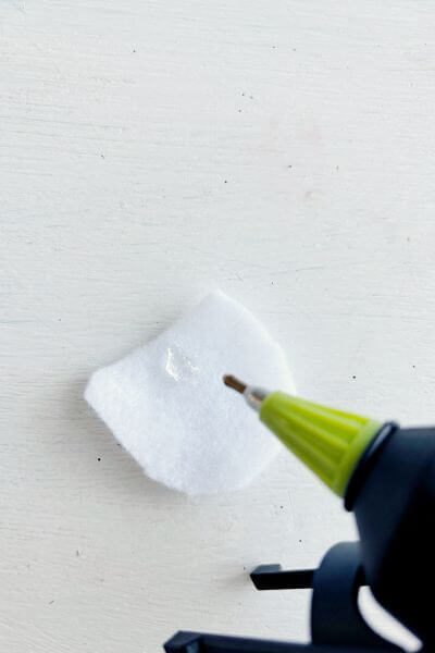 Place a drop of hot glue in the middle/top portion of the felt. 