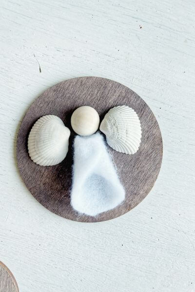 Position the dress, wood bead head and wings on the wood round to make sure it fits. 