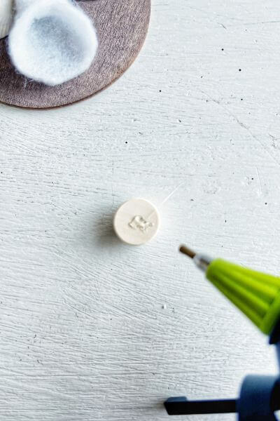 Place a dot of glue onto the half wood bead. 