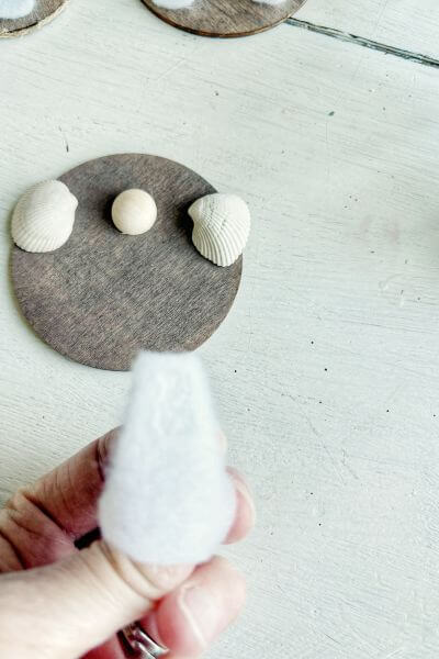 Place glue on the back of the felt dress. 