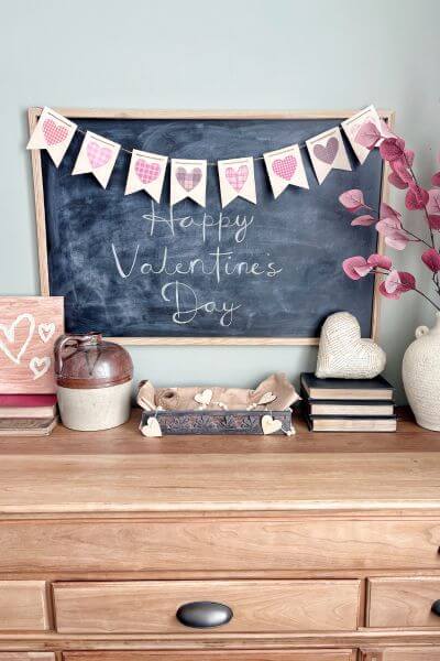 Large Valentine's Day banner hanging on chalkboard.
